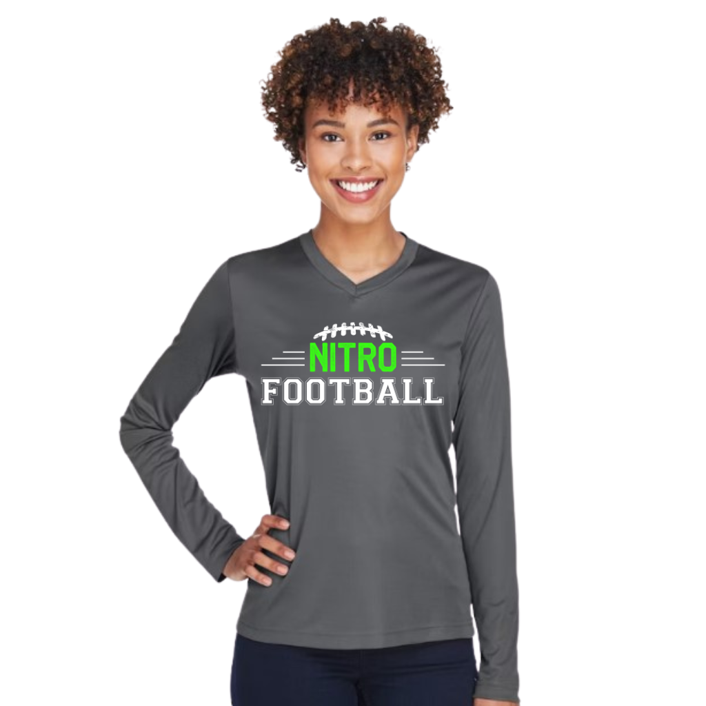Woman wearing a gray Long Sleeve Nitro Football shirt with green and white logo, smiling and posing with hand on hip.
