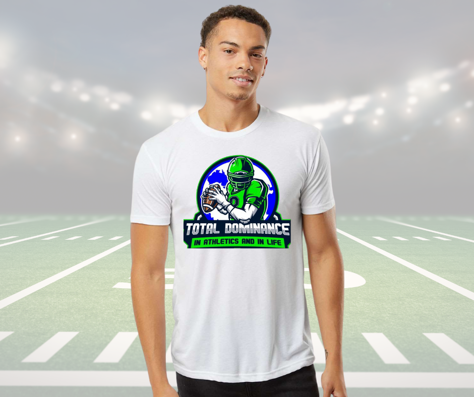 Man wearing a white customizable Total Dominance youth football team shirt with a green football player graphic on a stadium field.