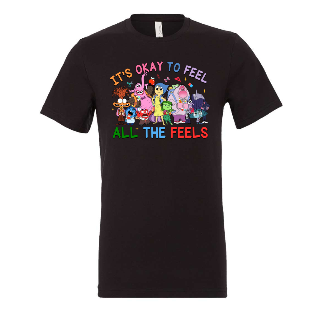 It's Ok To Feel All the Feels unisex shirt with colorful cartoon characters on black fabric.