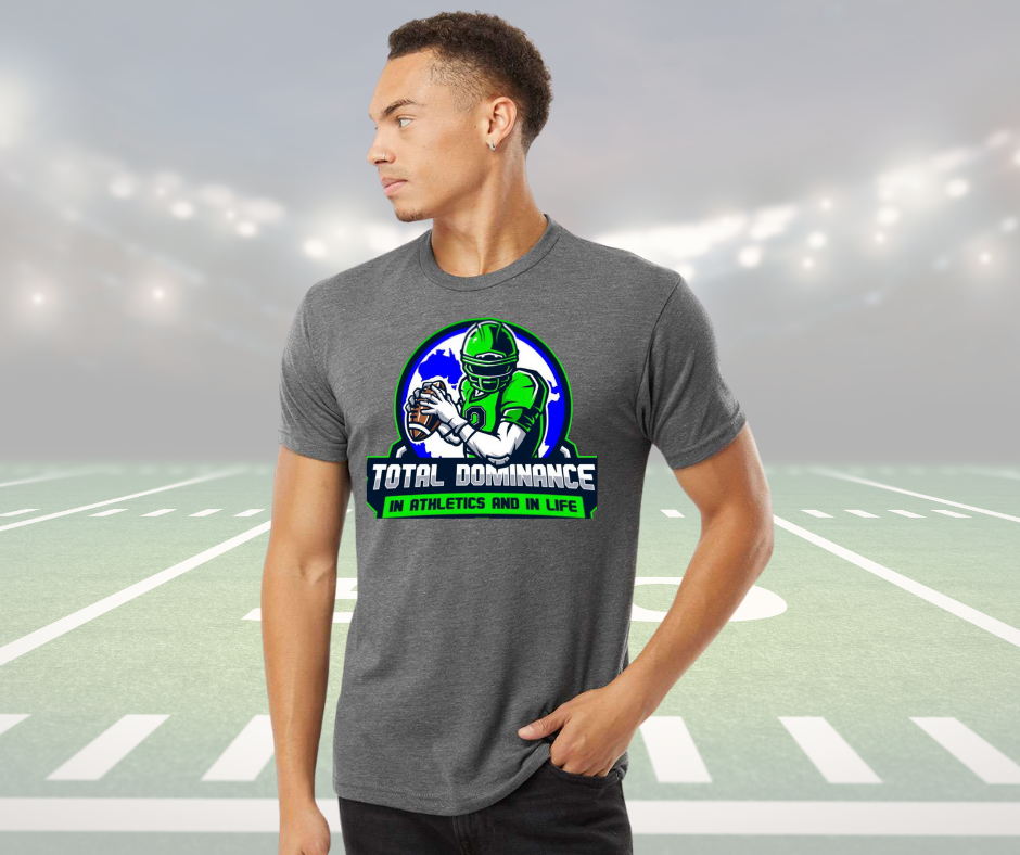 Man wearing gray Total Dominance youth football shirt with green player graphic on football field background