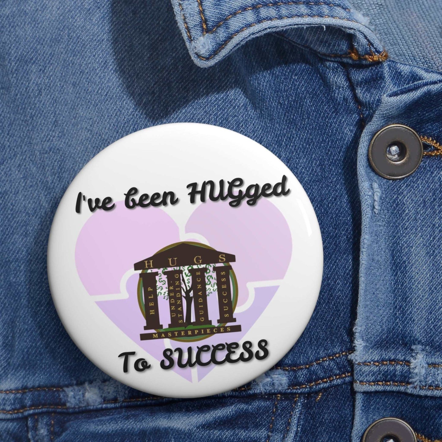 Glossy metal button pin with "I've Been HUGged to Success" text and colorful design on steel safety-pin back