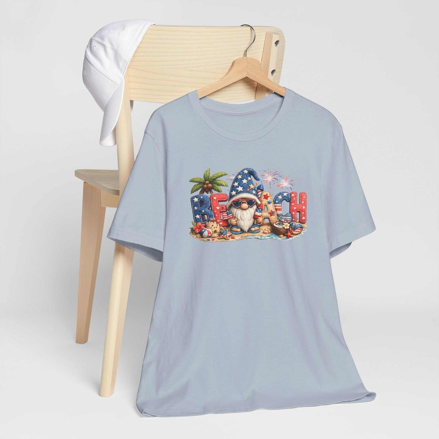 Patriotic Beach Gnome tee with red, white, and blue patchwork, fireworks, seashells, and coastal summer design