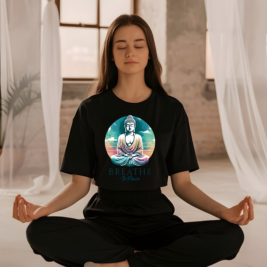 Person meditating wearing a black t-shirt with a Buddha graphic and 'Breathe' text.