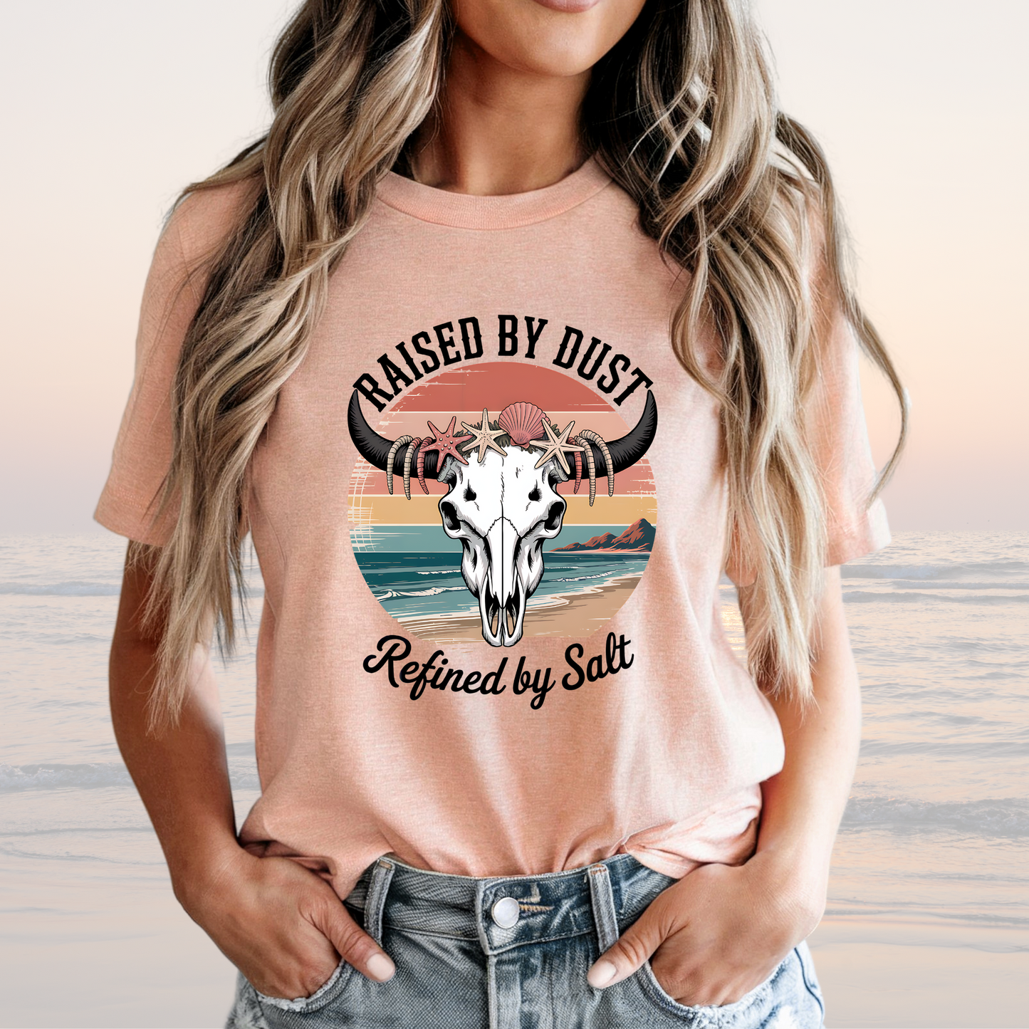 Raised by Dust Graphic T‑Shirt with Coastal Sunset and Bull Skull in Peach