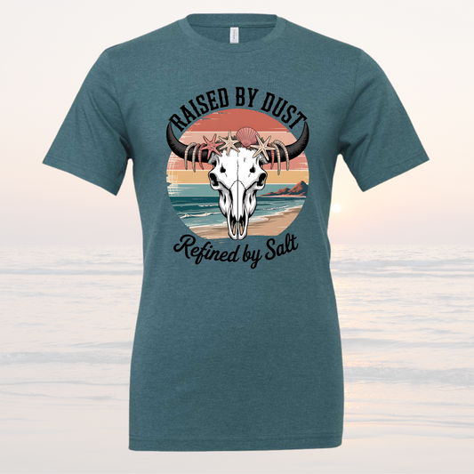 Raised by Dust Graphic T‑Shirt with Coastal Sunset and Bull Skull in Teal