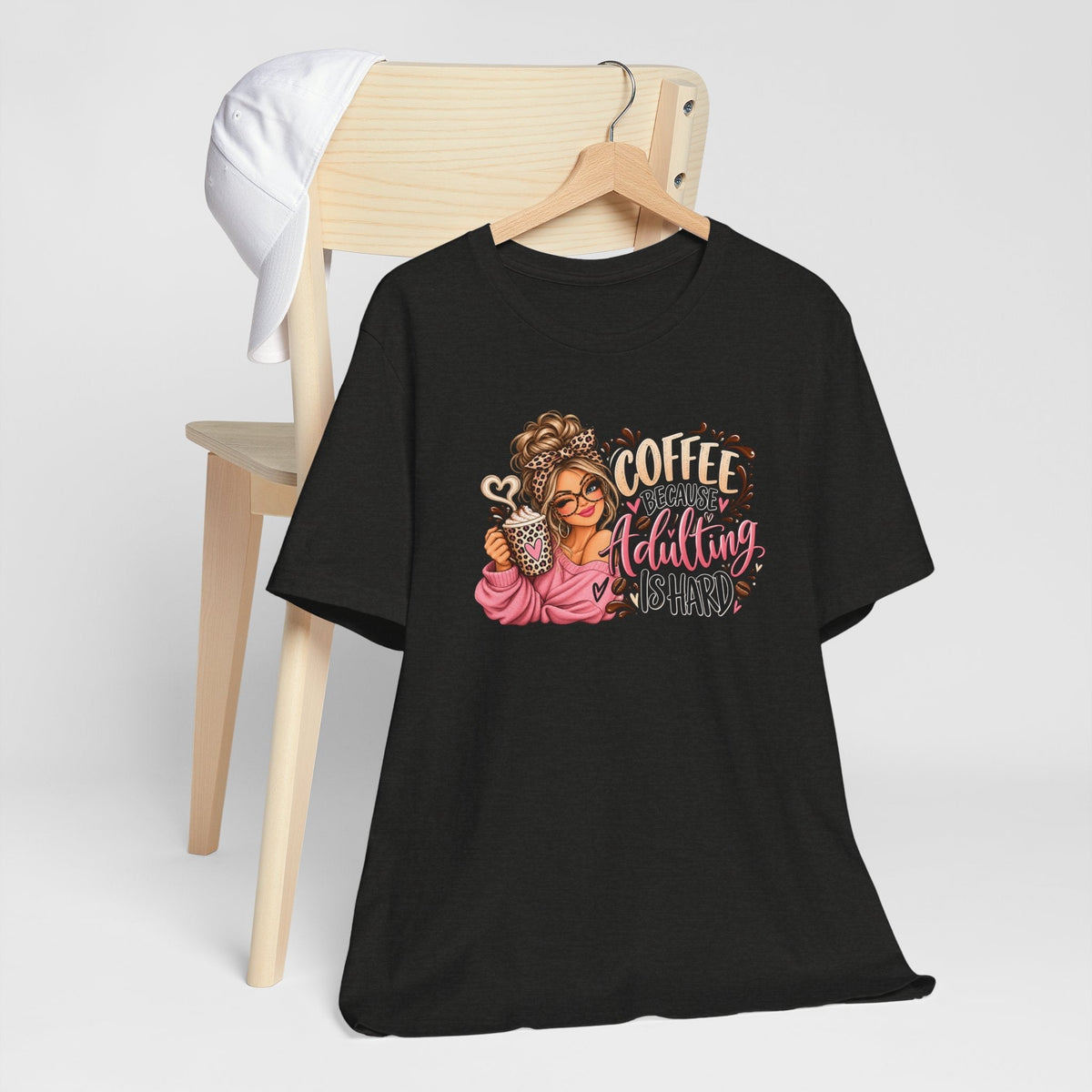 adulting tshirt in black with a colorful coffee-loving woman graphic, pink lettering, and leopard-print accents