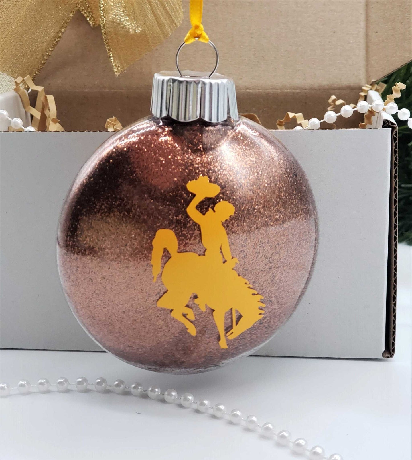 Wyoming Cowboy Ornament with yellow steamboat design, brown glitter, customizable for University of Wyoming fans.