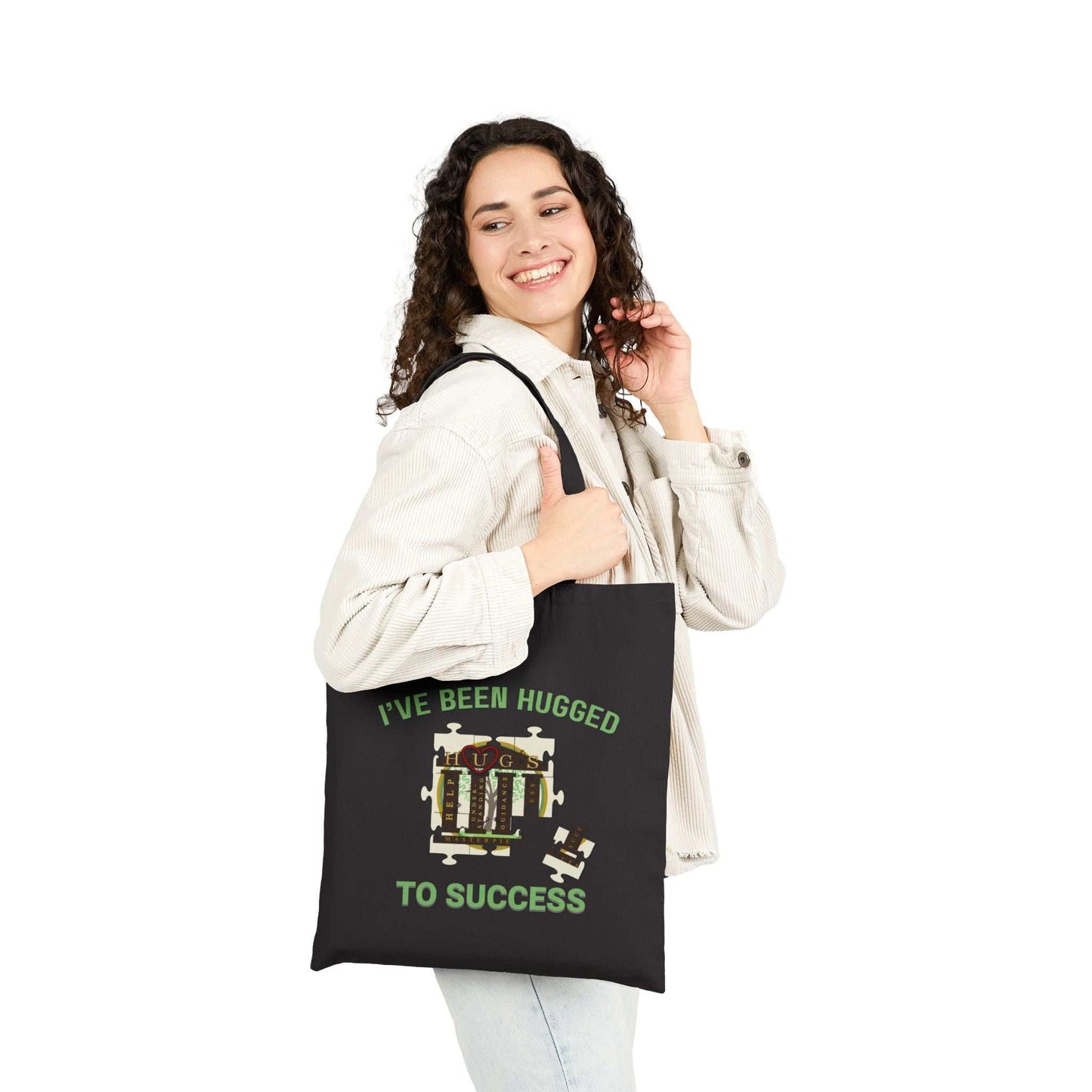 Durable cotton canvas tote bag with "I've Been Hugged to Success" print, flat-corner design, reinforced handles, available in natural and black.