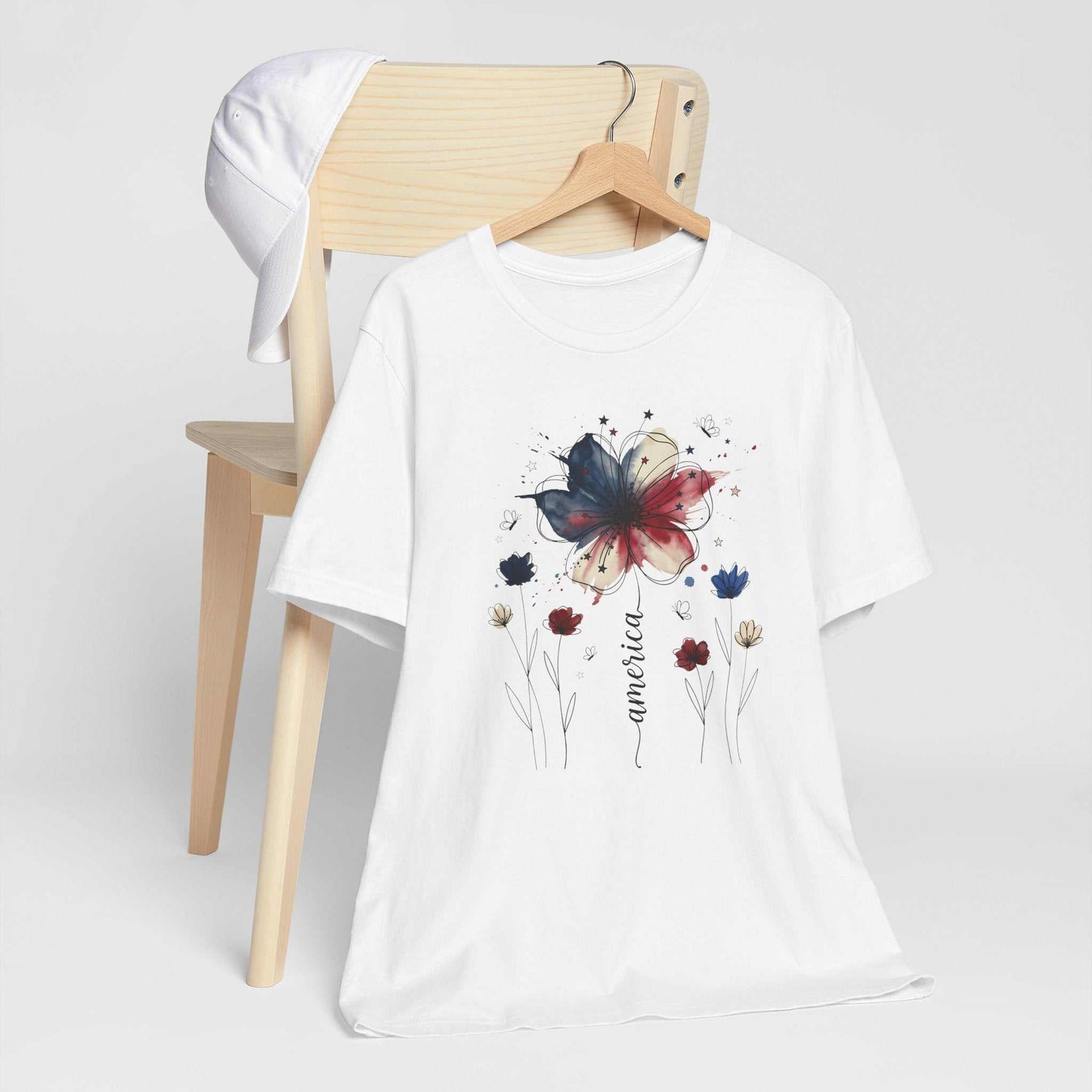 God Bless America Patriotic Floral Tee with red, white, blue watercolor florals, stars, and butterflies on soft Bella Canvas shirt