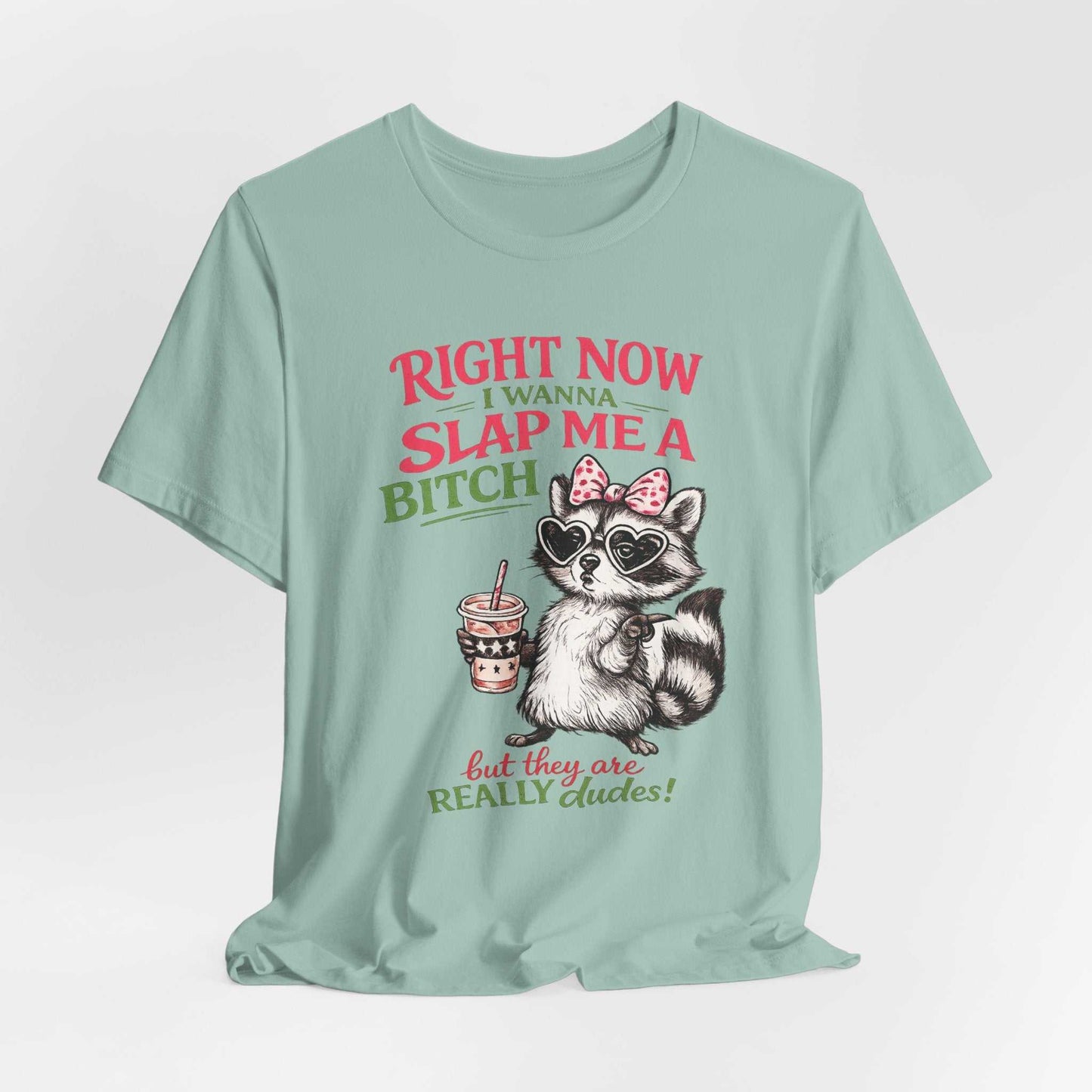 Funny raccoon graphic tee with "Right Now I Wanna Slap Me a BITCH" slogan, retro distressed pink and sage green lettering