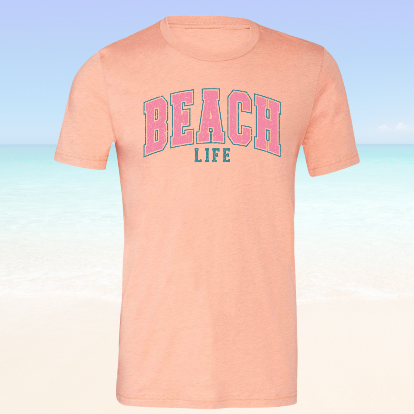 Beach Life Vibe Tee with pink "BEACH LIFE" text, perfect for casual beach style.
