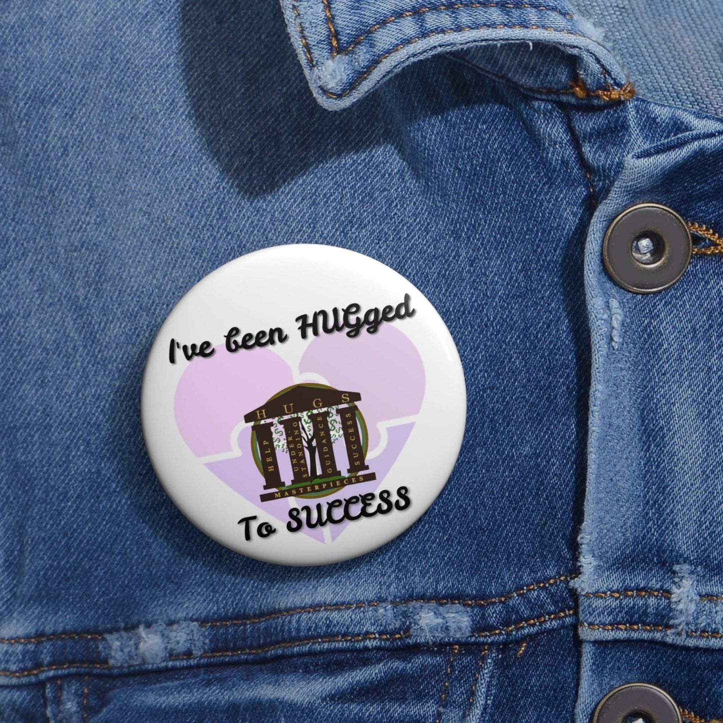 Glossy metal button pin with "I've Been HUGged to Success" design, durable mylar face, and steel safety-pin back