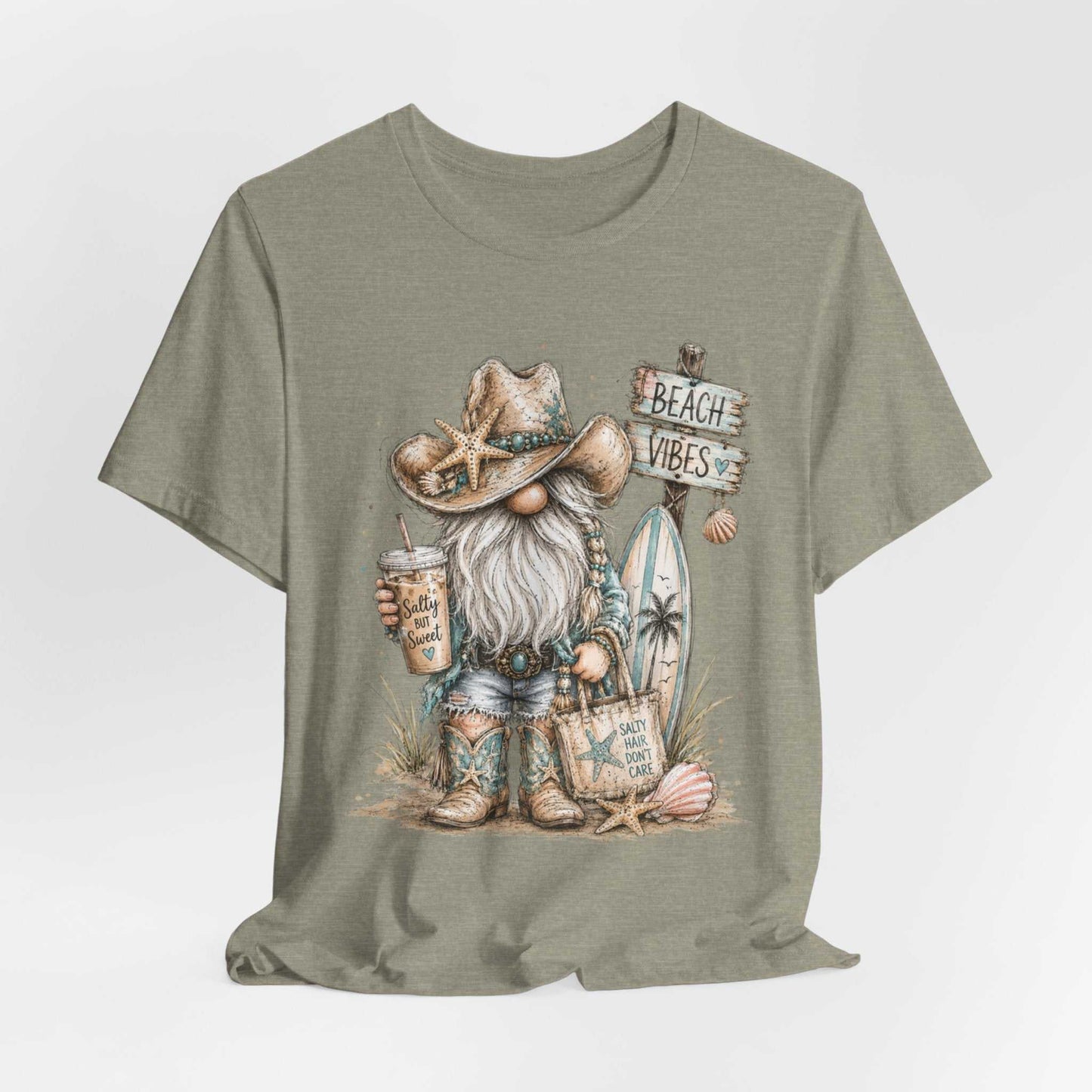 Coastal Cowgirl Beach Gnome graphic tee with turquoise accents and cowboy boots on a summer beach background