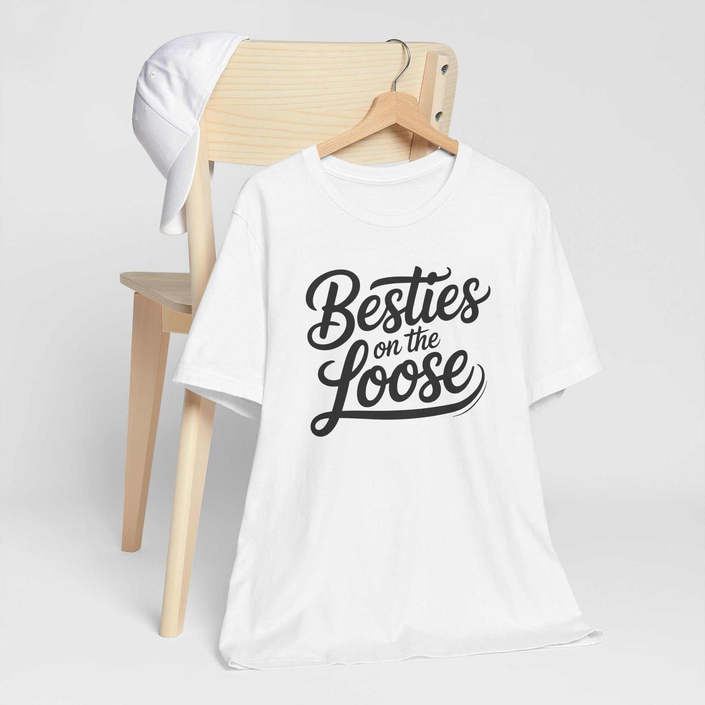 Group of women smiling and wearing Besties on the Loose Tee friendship t-shirts outdoors