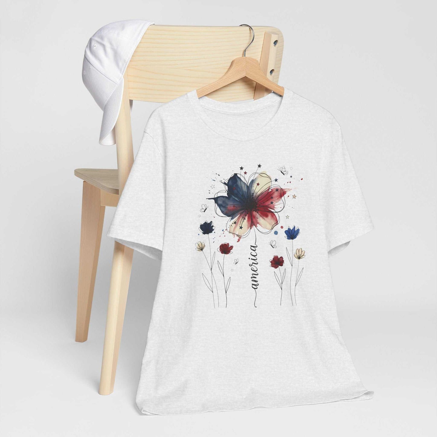 God Bless America Patriotic Floral Tee with red white and blue watercolor florals, stars, and butterflies on a soft Bella Canvas shirt