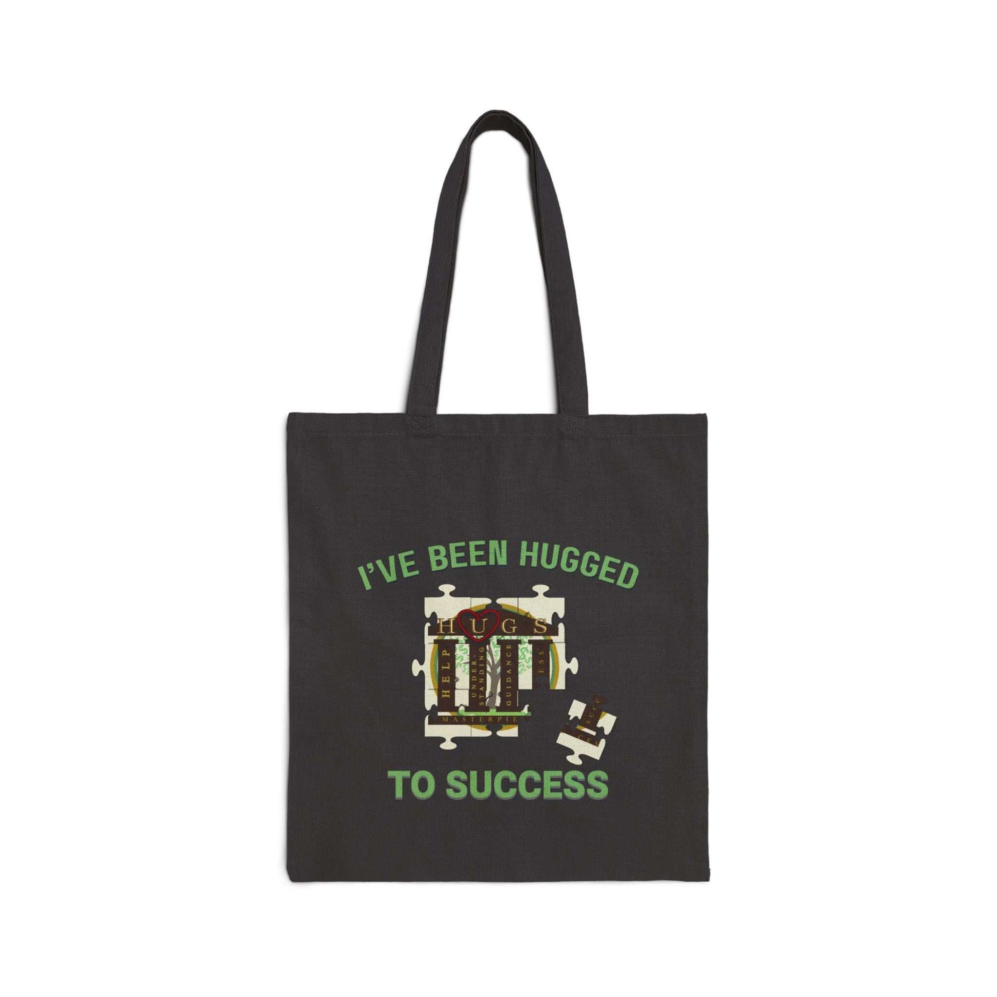 Natural cotton canvas tote bag with "I've Been Hugged to Success" print, sturdy handles, and flat-corner design.