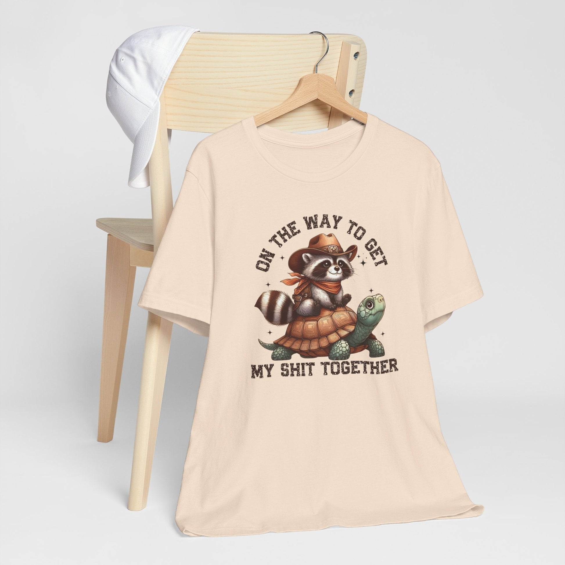 Cowboy raccoon riding turtle graphic on funny western t-shirt with humorous text