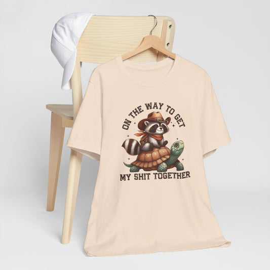 Cowboy raccoon riding turtle graphic on funny western t-shirt with humorous text