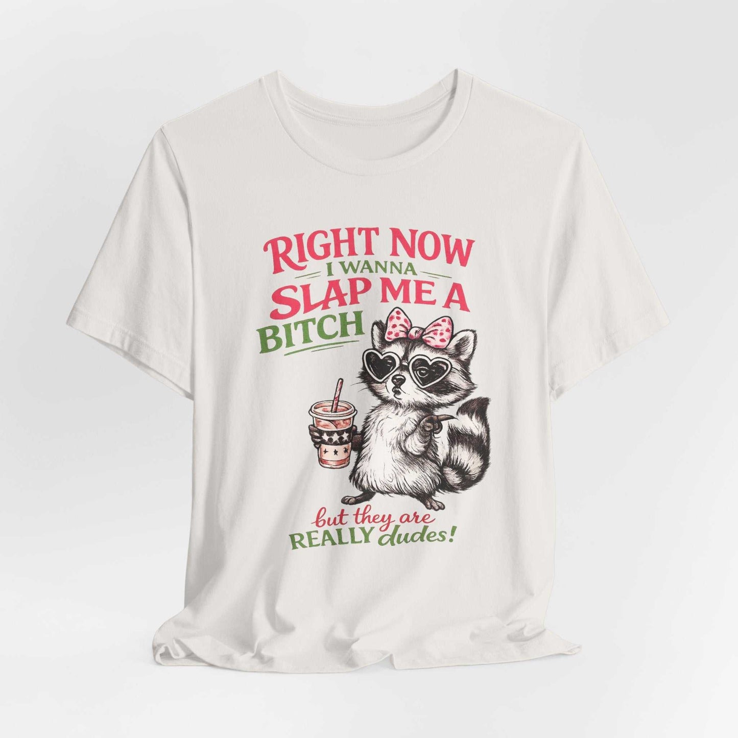Right Now I Wanna Slap Me a BITCH raccoon graphic tee with heart sunglasses and pink bow in retro distressed pink and sage green lettering