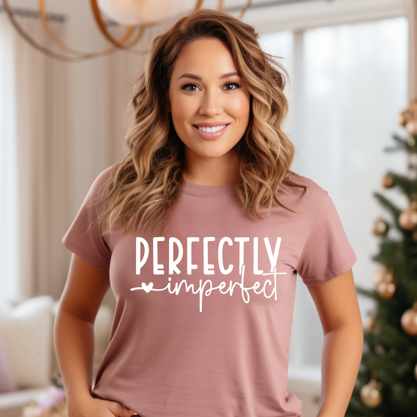 Perfectly Imperfect Tee worn by a smiling woman in a cozy living room.