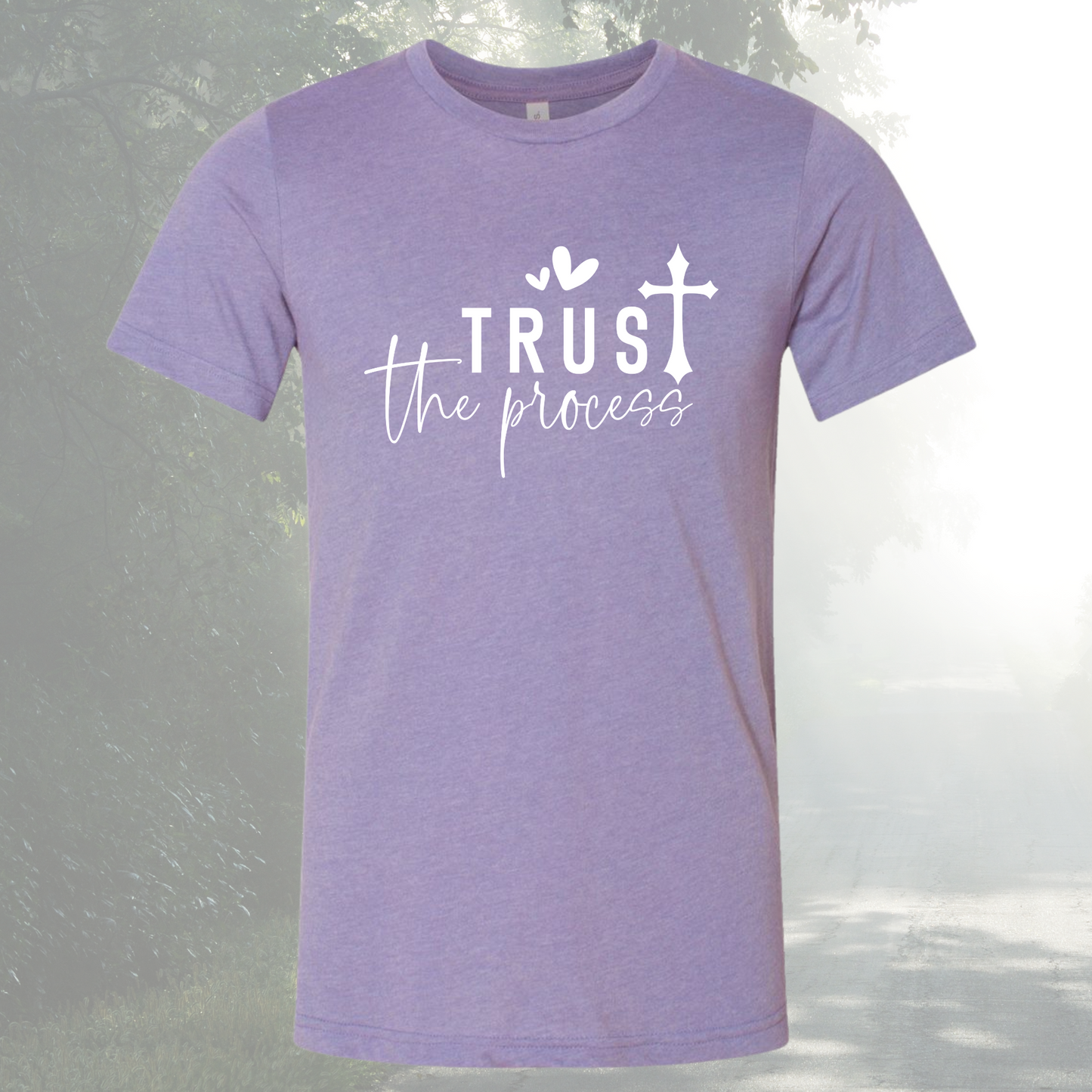 Unisex purple tee with "Trust The Process" design on a misty background.