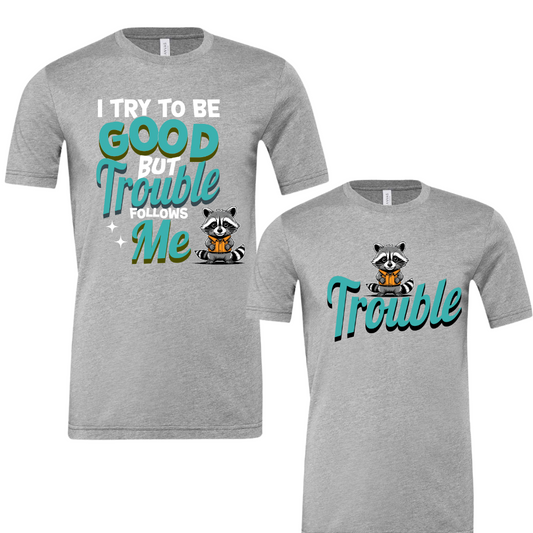 Unisex "Trouble Follows Me" shirt with raccoon graphic, soft fabric, matching option.