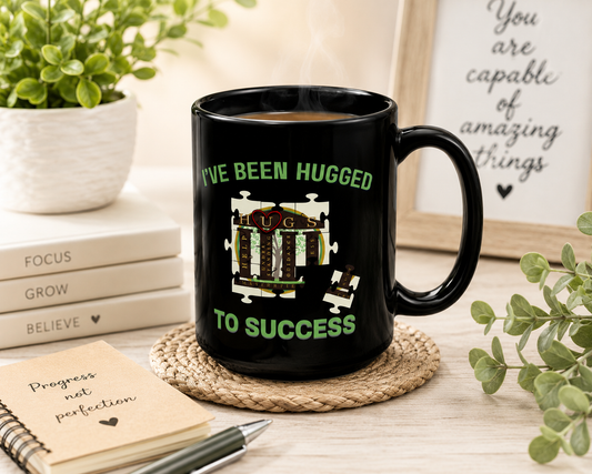 Black coffee mug with "I've Been HUGGed to Success" vibrant design, 15 oz glossy ceramic with C-handle