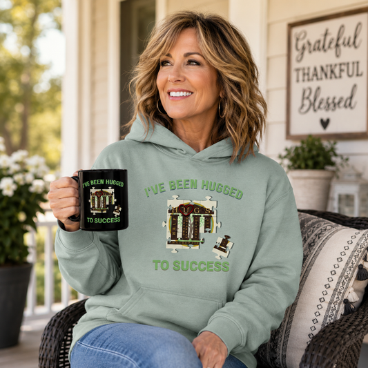 I've Been Hugged to Success Hoodie with puzzle-piece design symbolizing growth and connection, soft cozy fleece for HUGS graduates and affiliates
