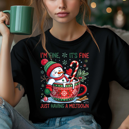 Person wearing a black t-shirt with a Christmas-themed design, holding a green mug.