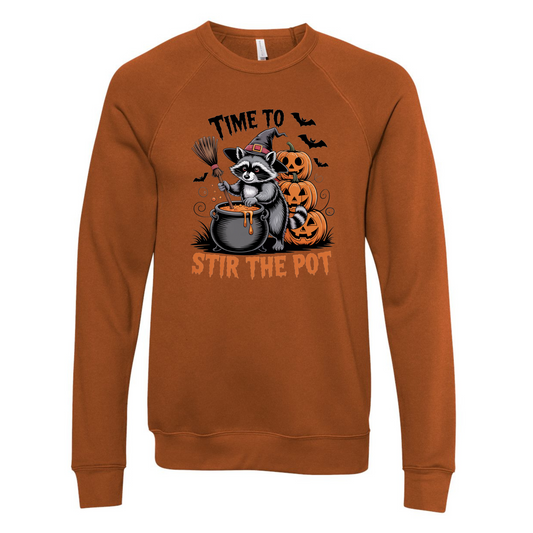 Brown sweatshirt with Halloween-themed graphic featuring a raccoon and pumpkins on a white background.