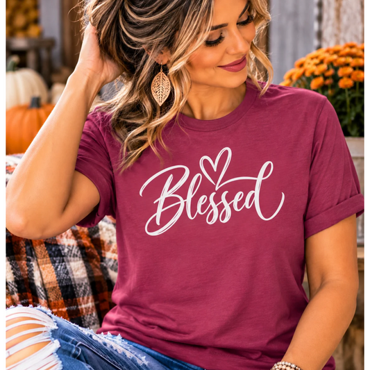 Woman wearing a berry Blessed graphic tee with white script lettering and a heart