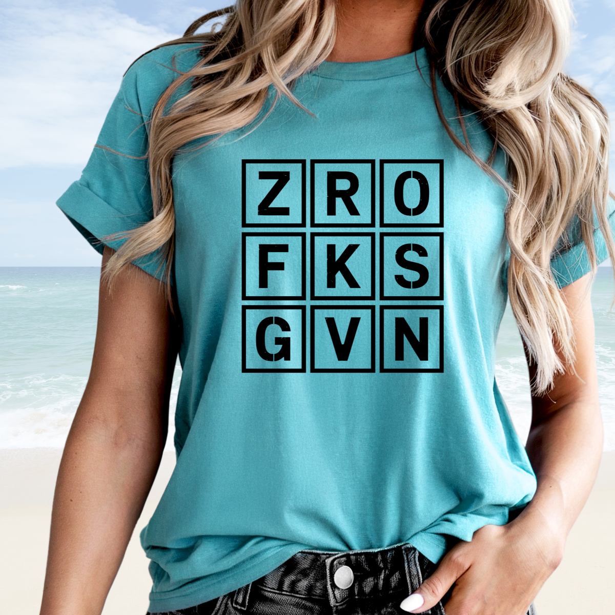 Adult humor shirt in turquoise cotton with a bold black letter-grid graphic spelling ZRO FKS GVN
