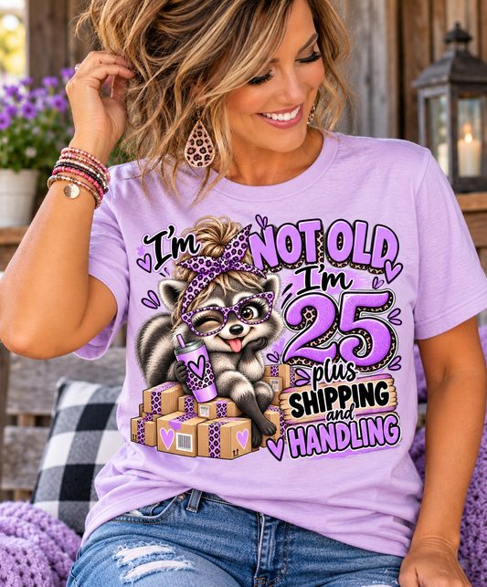 adult humor tshirt in lilac cotton with a playful raccoon, purple leopard-print bow, packages, and birthday slogan