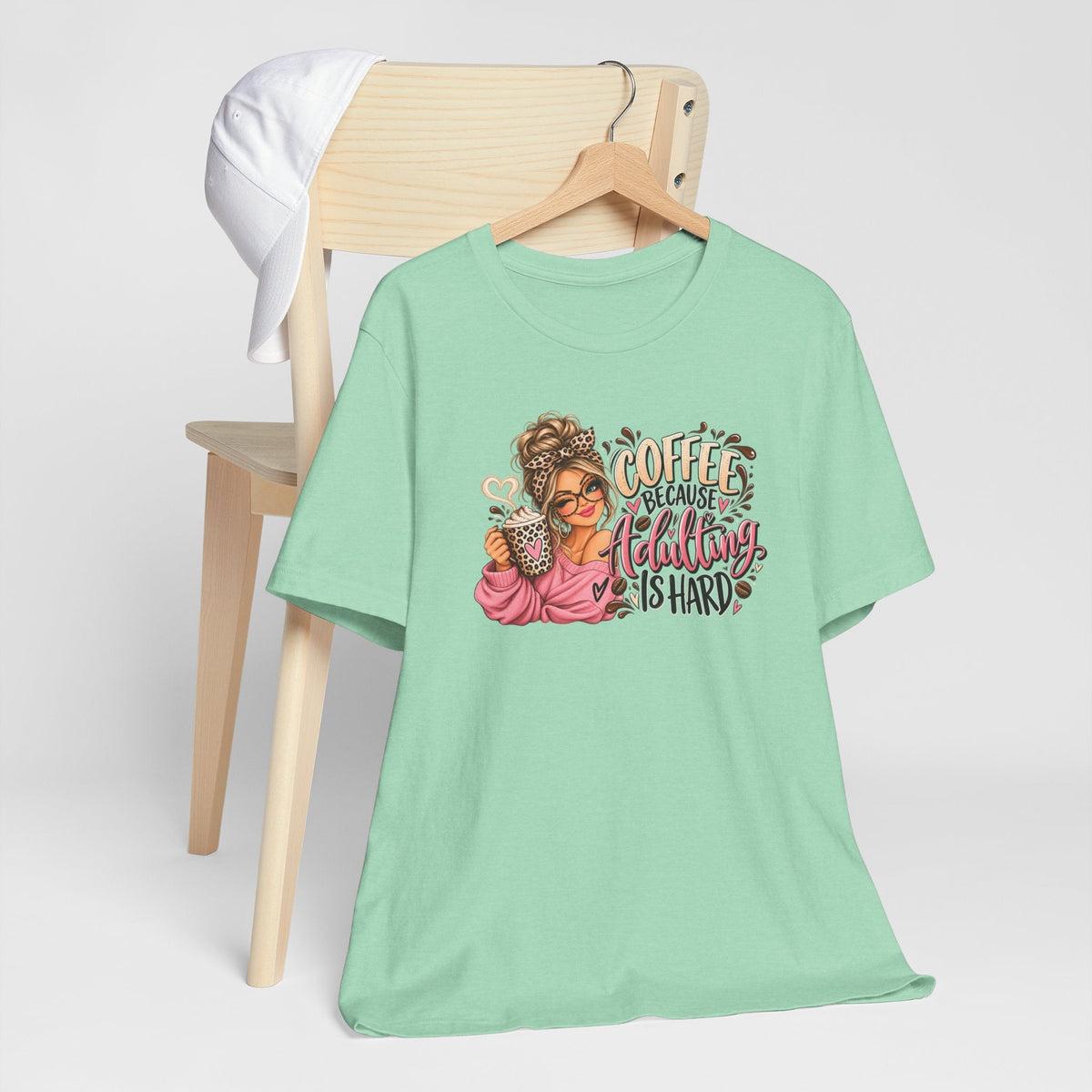 adulting tshirt in mint green with a colorful coffee girl graphic, messy bun, and playful lettering