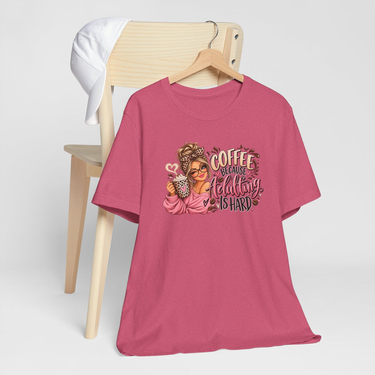 adulting tshirt in pink with a colorful coffee-loving woman graphic and playful lettering that reads “Coffee Because Adulting Is Hard”