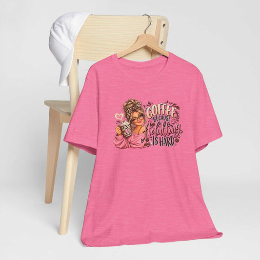 Pink adulting tshirt with a colorful coffee-loving woman graphic, leopard-print accents, and playful lettering