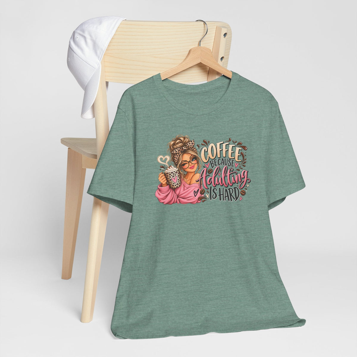 adulting tshirt in muted sage green with a colorful coffee-loving woman graphic and playful lettering