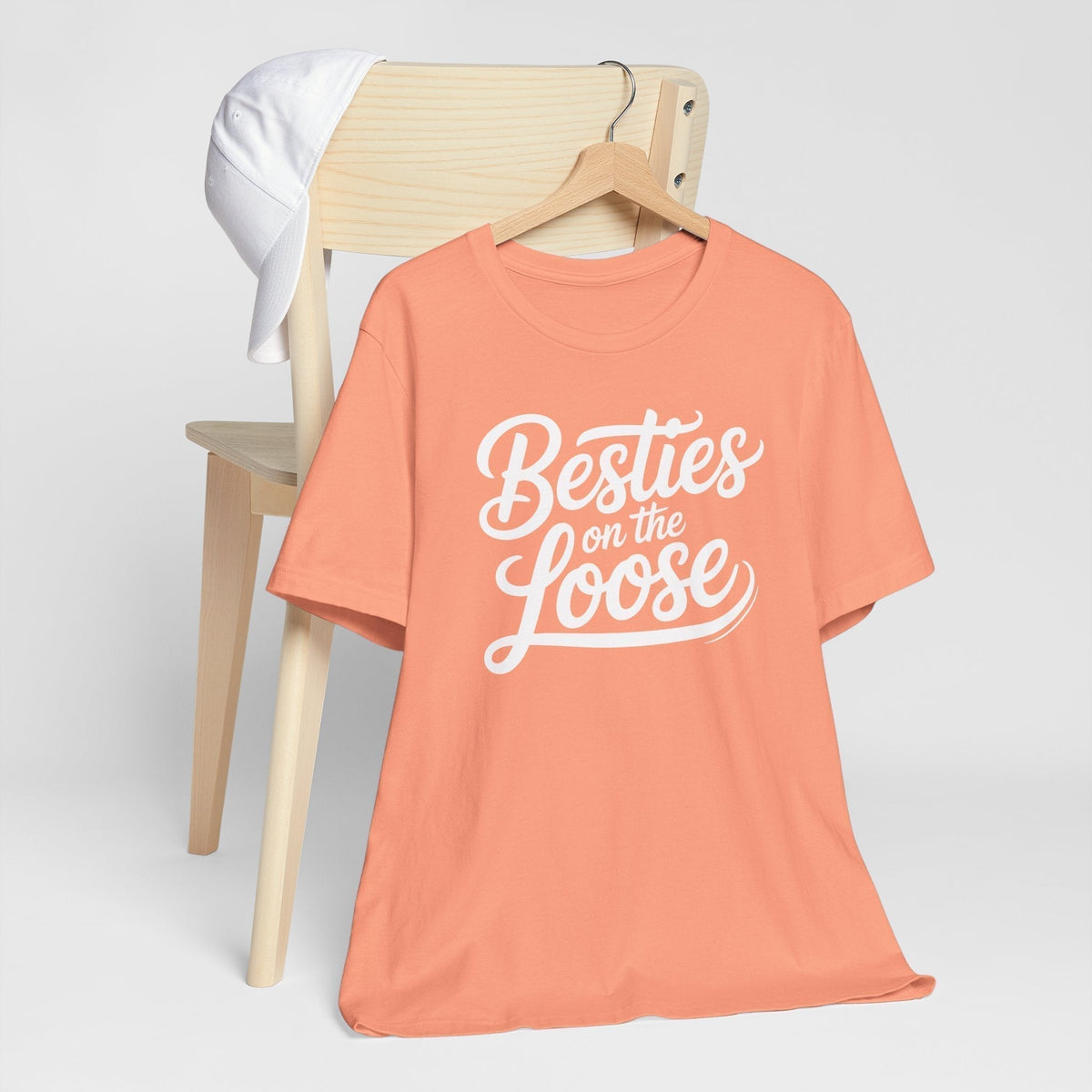 best friend funny tshirt in coral cotton with short sleeves and white cursive “Besties on the Loose” graphic