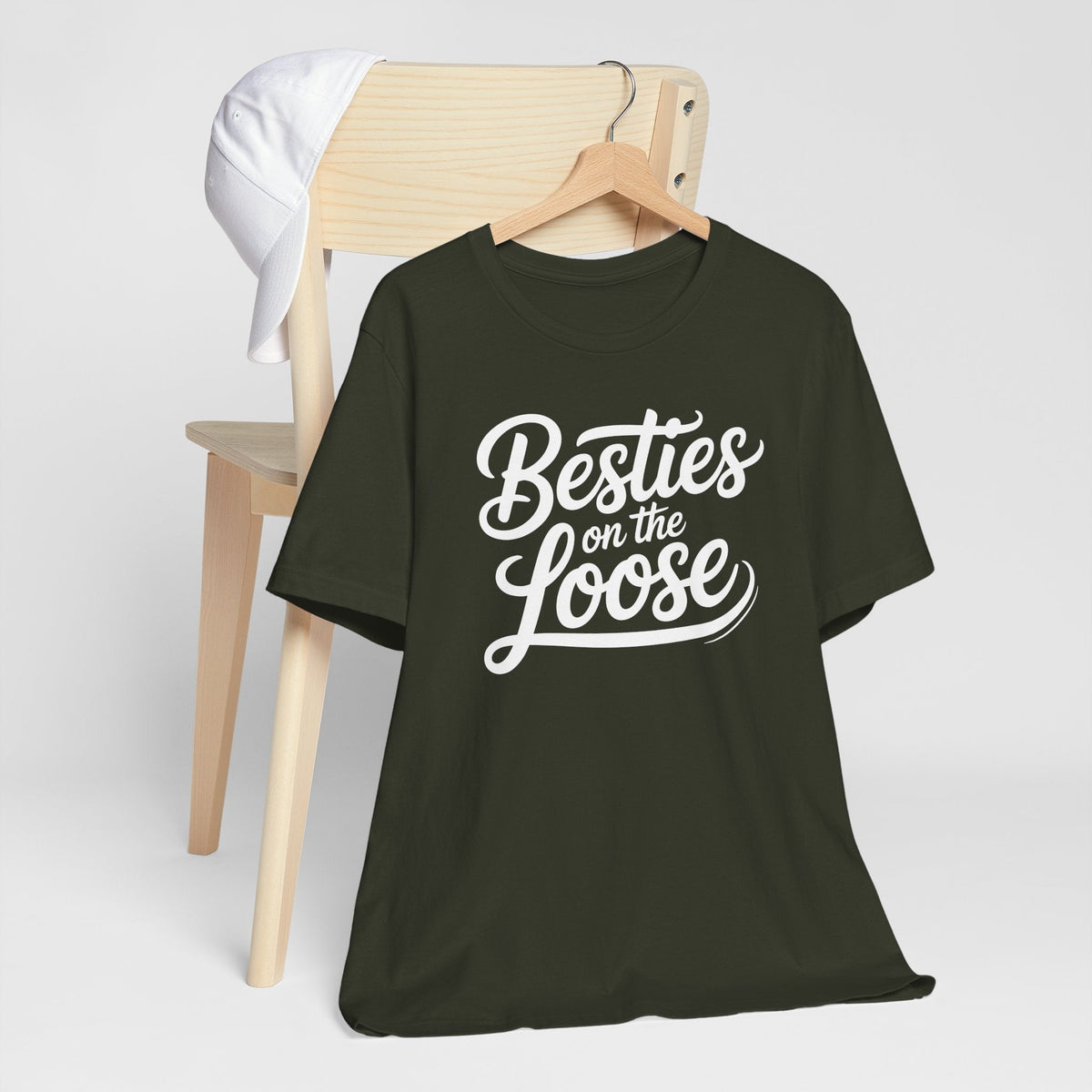 best friend funny tshirt in dark olive green with short sleeves and white script reading “Besties on the Loose”