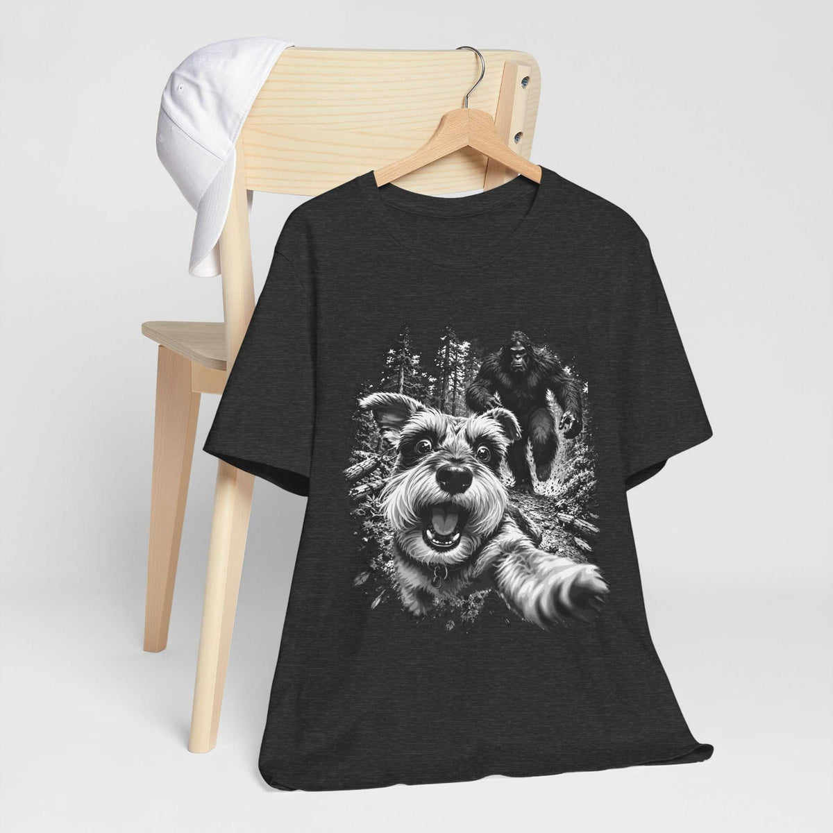 bigfoot shirt in charcoal black with a white and gray graphic of a running dog and Bigfoot in a forest