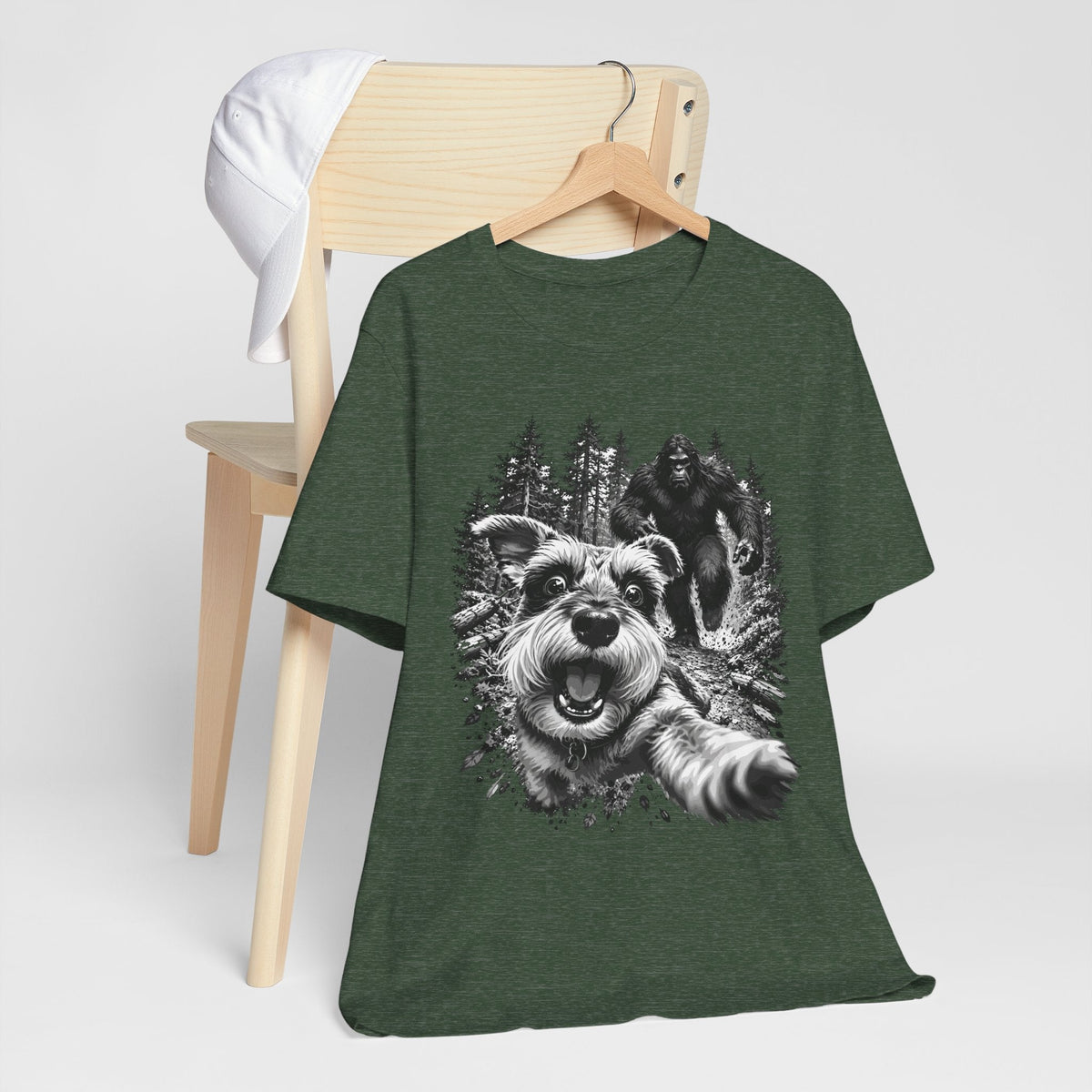 Bigfoot shirt in dark green with a monochrome graphic of a running dog and Sasquatch among trees