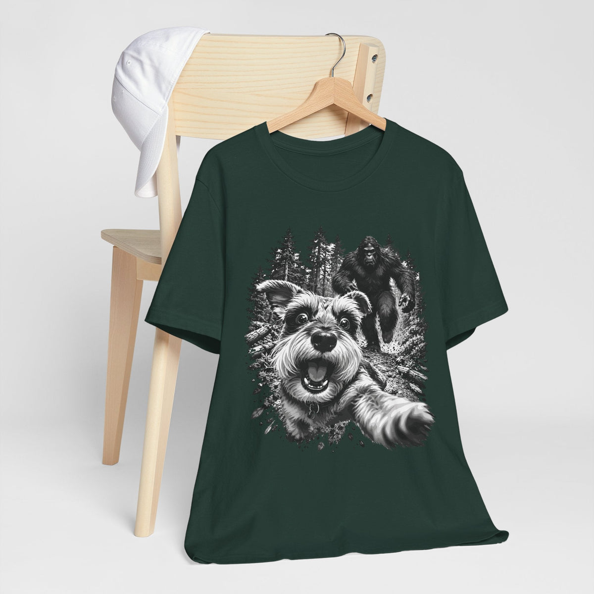 bigfoot shirt in dark green with a monochrome graphic of a running dog, trees, and Sasquatch
