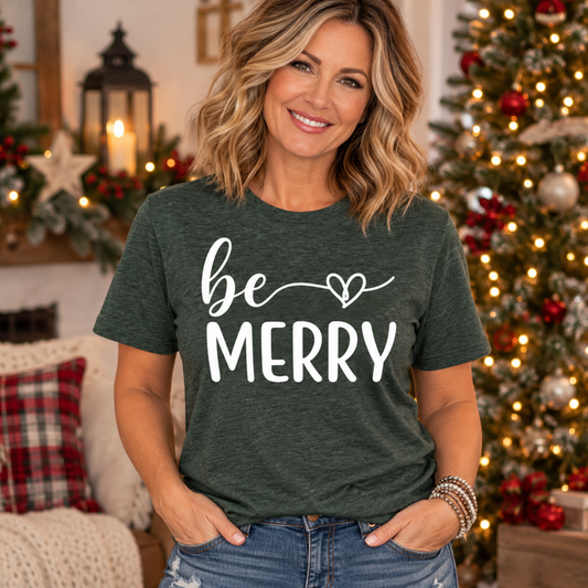 christmas graphic tee shirt in dark heather green with white “be MERRY” lettering, flowing script and heart detail