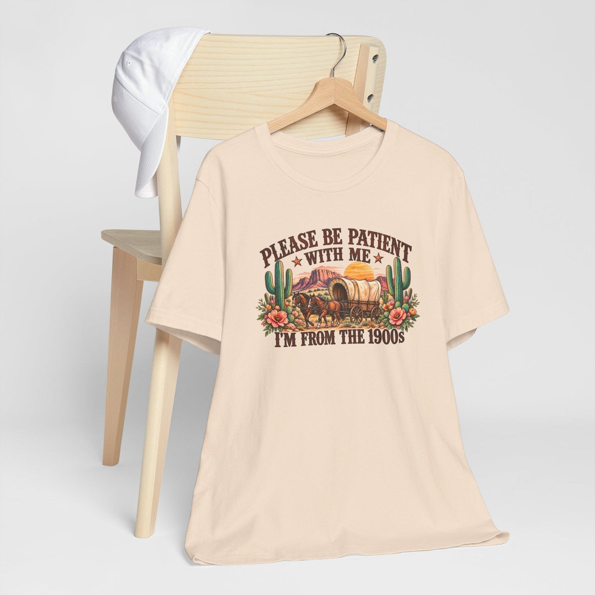 Cowgirl graphic tshirt in cream cotton with a colorful vintage western wagon, cacti, flowers and humorous text