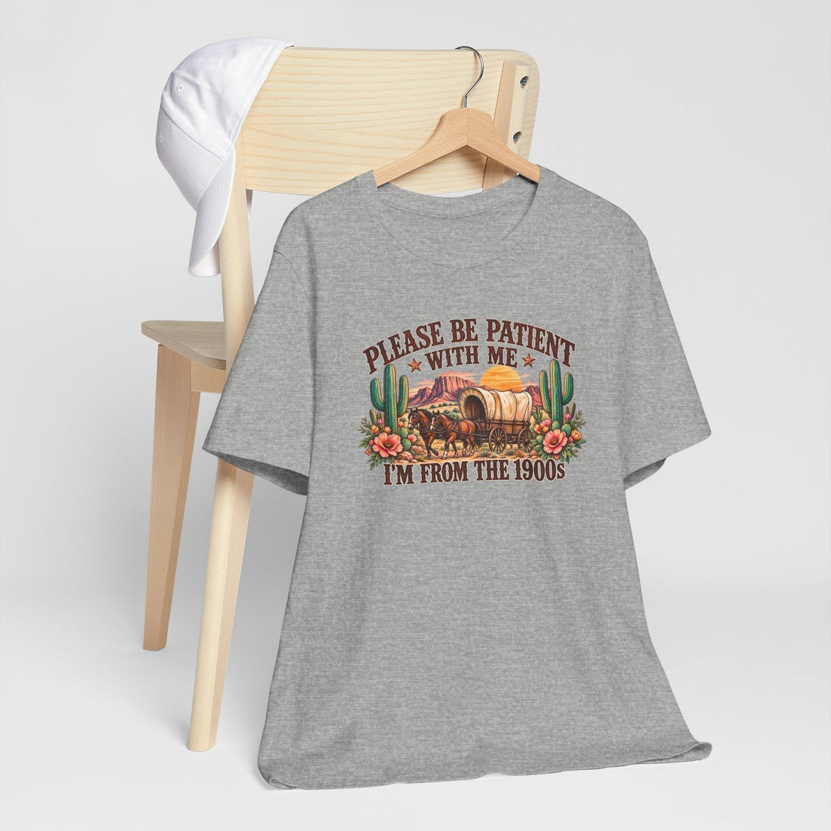 cowgirl graphic tshirt in heather gray with a vintage western wagon, desert flowers, cacti, and nostalgic text