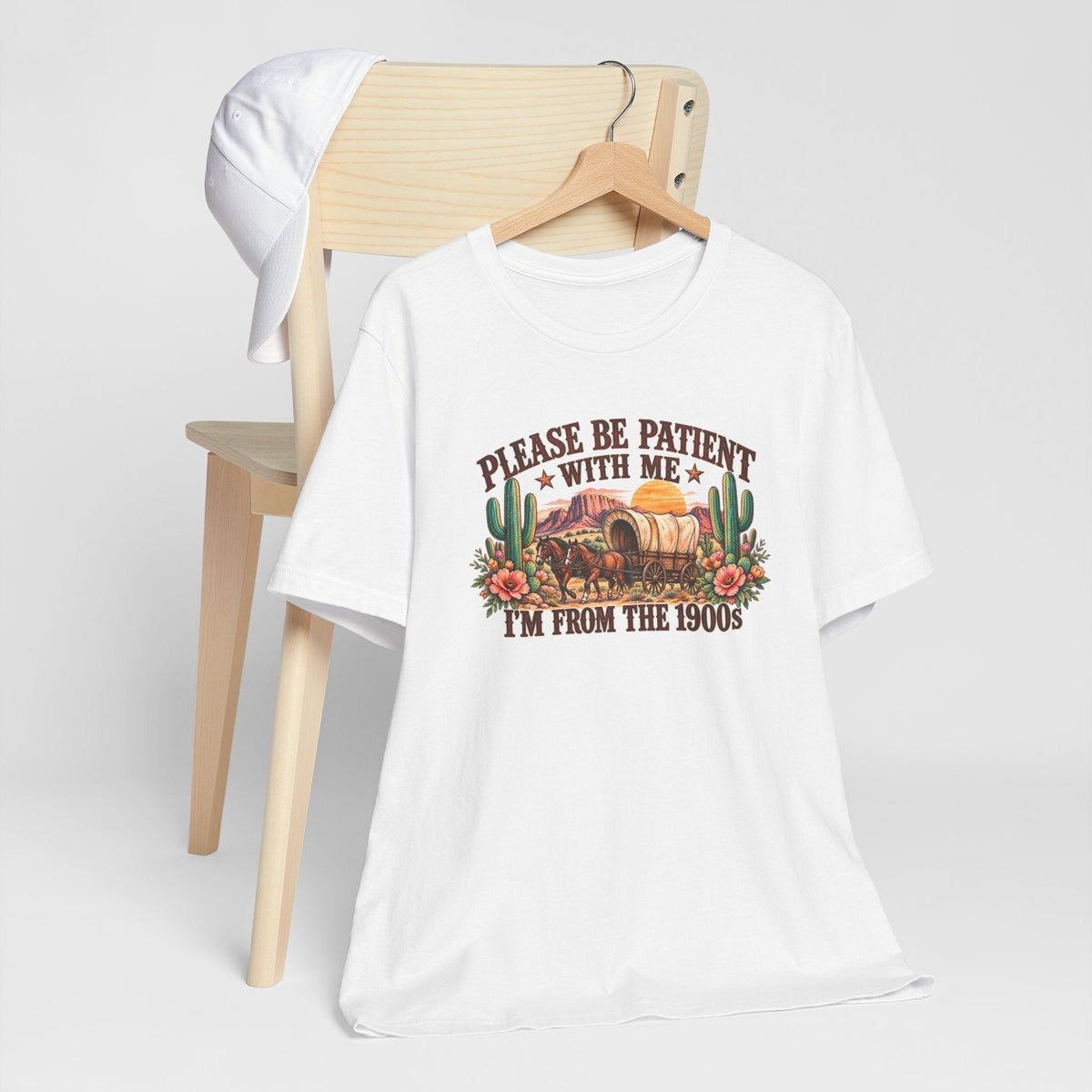cowgirl graphic tshirt in white cotton with a colorful vintage western wagon, cactus, flowers, and humorous text