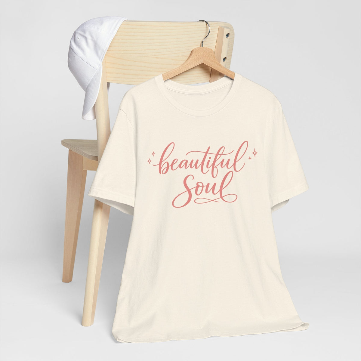 Graphic T-shirt in cream cotton with coral-pink “Beautiful Soul” script and small sparkle accents, among cute graphic tees.