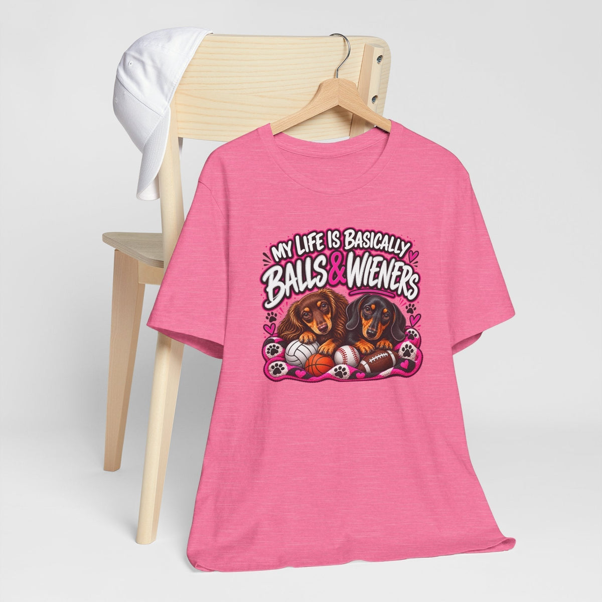 funny dachshund graphic tee in bright pink with a colorful design of two dachshunds, sports balls and playful lettering