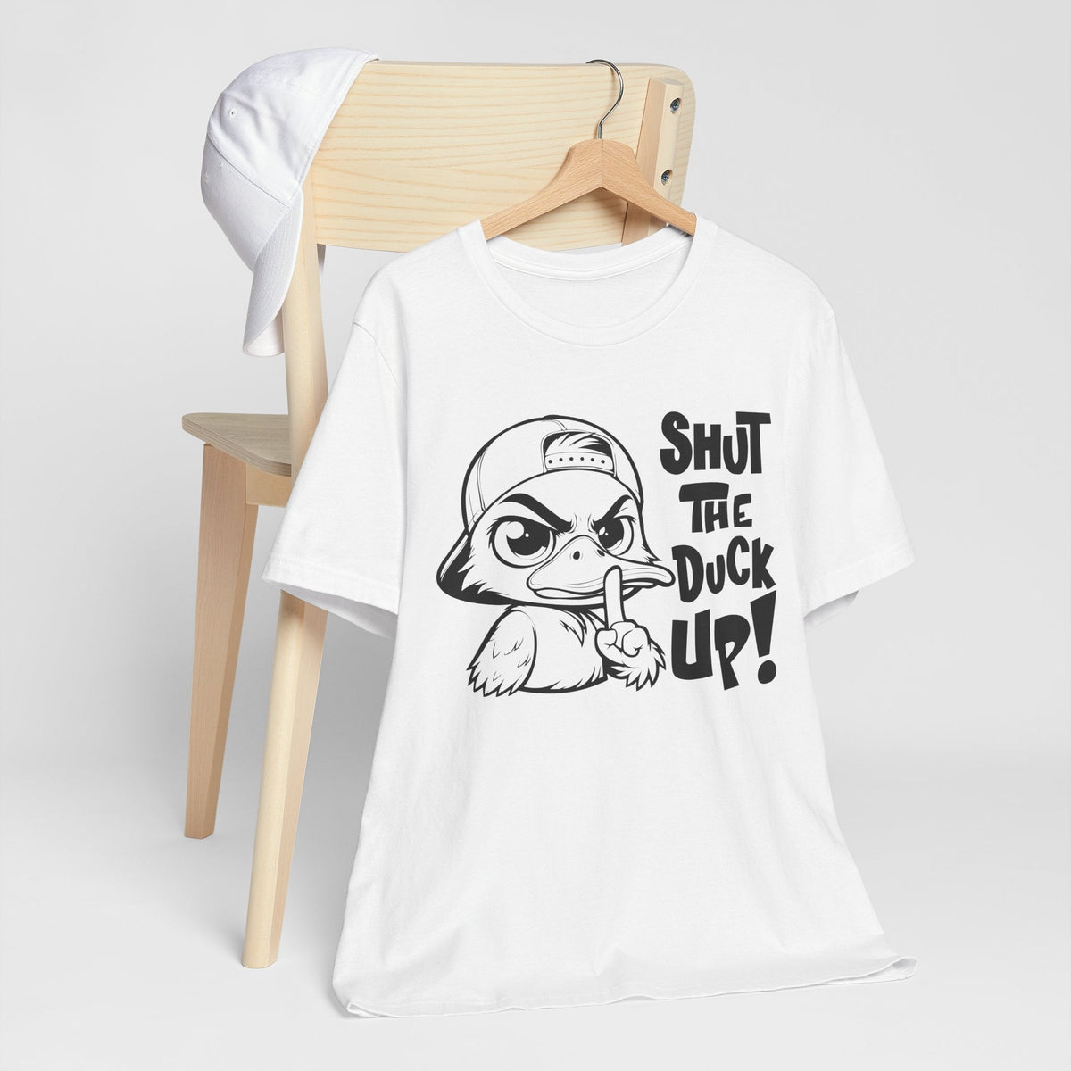 White cotton graphic tee with a black-and-white cartoon duck and bold “Shut The Duck Up!” text, among funny graphic tees for ladies