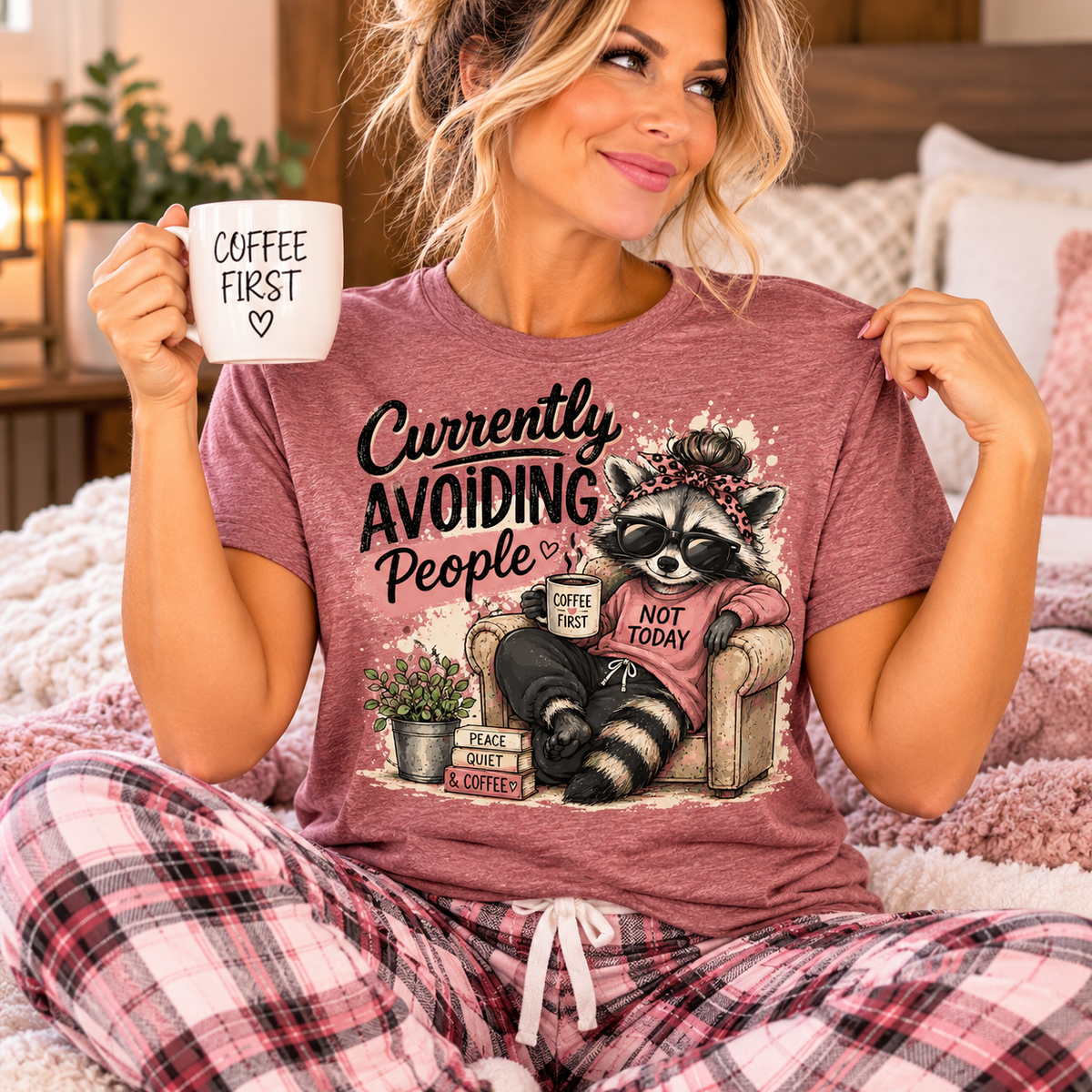 funny tee shirt in muted mauve with a graphic of a sunglasses-wearing raccoon lounging in a chair with coffee